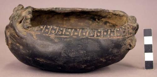 Ceramic black bowl with applied human and reptile figure respectively on each end