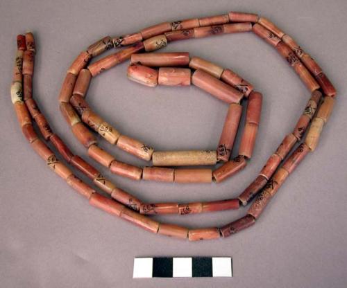 Ground stone, necklace of tubular carnelian beads