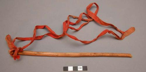 Plains stick w/ a strip of red cloth tied to it, possibly from a medicine bundle