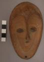 Bwami society maskette, kindi grade; heart shaped face rimmed with punctates