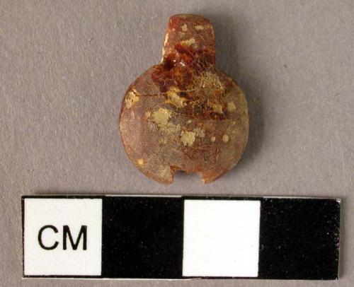 Disk-shaped amber pendant with square suspension tab, cross-drilled.