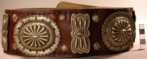 Leather belt, rectangular buckle with designs, 7 oval silver conchas with emboss