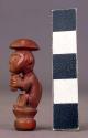 Small seated pottery figurine - monkey with human face; hole in bottom; used as