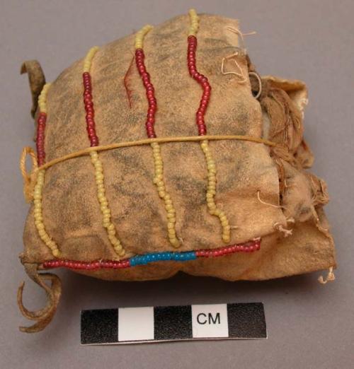 Female amulet--skin with 2 tails at lower corners; edged with red and blue beads