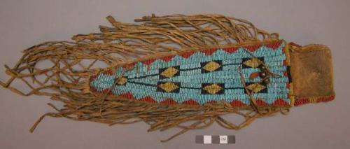 Multicolored beaded piece of hide decoration with a hide fringe in form of a kni