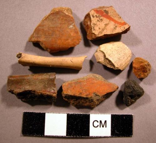 Ceramic sherds, 4 red slip, 1 red on buff, 1 charred, 2 bone frags, 1 charcoal f