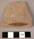 Ground stone fragment, corner of palette?, square and smooth