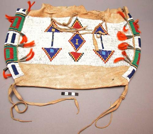 Skin saddle bag with bead decoration, orange tassels