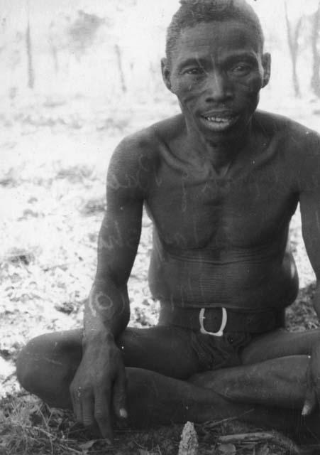 Kumsa (Headman of Band II, husband of N/ai/shi (2nd wi) and father of Mishi) sitting