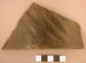 Polished black diagonally grooved rim potsherd