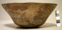 Bowl painted in polychrome with interlocking fish/serpents above human faces
