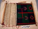 Small loom showing blanket in process of manufacture- green, blue & red