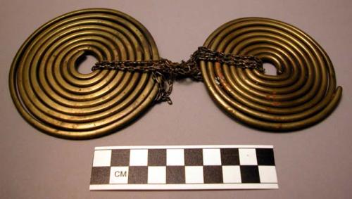 Pair flat coiled brass breast ornaments