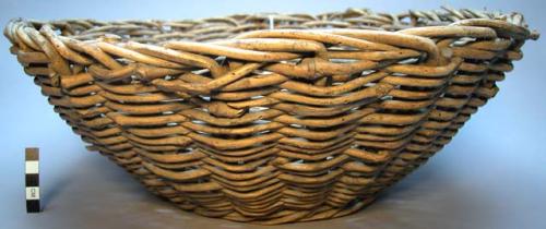 Basket, woven wooden sticks or vines, flat base, flared body, plain.