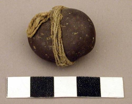 Raw material, smooth pebble tied with twine