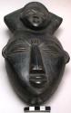 Baule head and hat, hat has smaller face decoration, wood with black paint