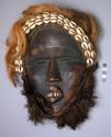Poro mask, wood, cloth, cowries, hair (or feathers) and metal, 11.5 +