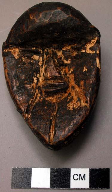 Miniature wooden face mask.