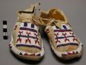 Pair of child's leather moccasins with red, white & blue bead *