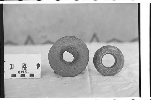 Two stone rings, left one with material in hole. Right one polished.