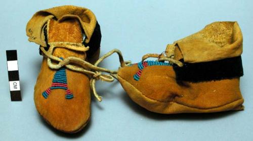 Pair of children's moccasins; top, triangular beaded pattern in blue and red