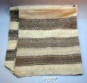 Woolen cloth used for winnowing and for carrying harvest; black & +