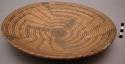 Basketry tray. coiled. Geometric pattern in brown. 13" (diameter).