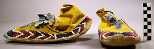 Pair of small low-cut moccasins. Died yellow upper hide; dyed blue 'tongue;' ra