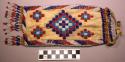 Beaded pouch. Made of buckskin. Red, white, blue, and yellow beadwork.