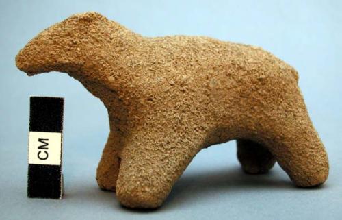 Unfired clay figurine depicting animal (sheep?)