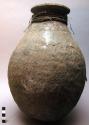 Large jar-shaped pottery vessel - coarse plain ware, fibre attachment around nec