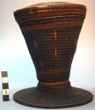 One black basketry container with cover, yellow design