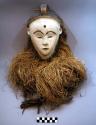 Mask with white face and raffia hair