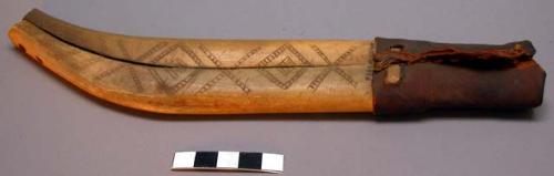 Sheath of knife made of 2 pieces of bone with incised geometric design.