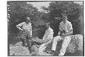 Staff members sitting on rocks next to river