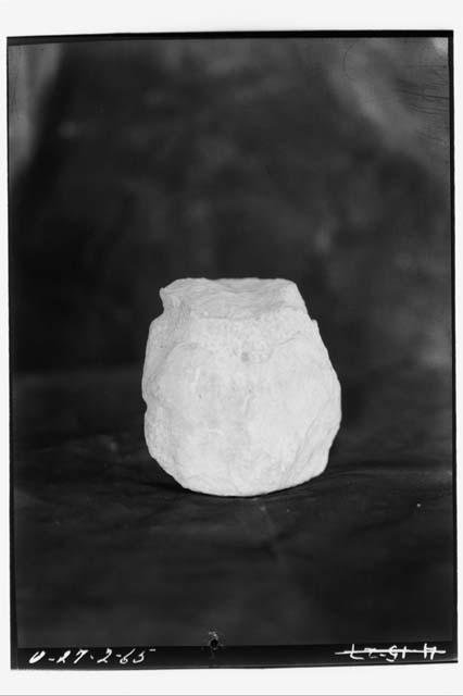 Limestone human figurine in sqatting position, head gone from rubble of E-VII se