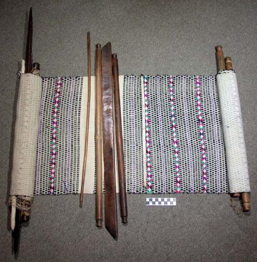 Loom, with textile in process of manufacture