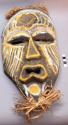 Carved wood mask with yellow and white painted decoration and raffia trim