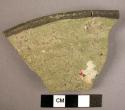 Ceramic rim sherd, overfired, greenish ware w. black painted rim