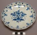 Plate. white clay. white glaze with blue border and central floral design. Scall