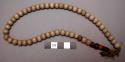 Necklace, white beads with few colored ones at end, olunigi lwomukala