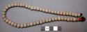 Necklace, white beads with single orange bead, olunigi lwomukala