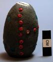 Ovate ball of clay, im-bedded with cowrie & glass beads