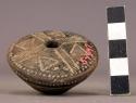 Terra cotta spindle whorl ornamented with incised lines