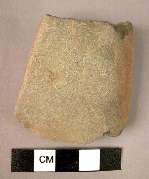 Partially smoothed stone celt (adze), broken