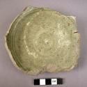 Ceramic partial dish, green glaz, incised circles, ring base