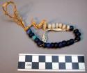 26 old glass beads, blue and white, strung on grass. Tunduru