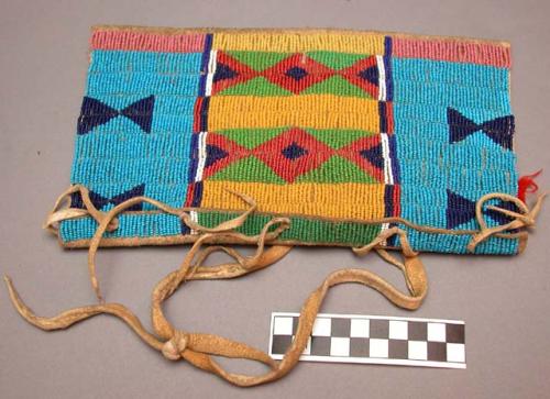 Skin pouch--thong handle. trimmed with blue and yellow beads.