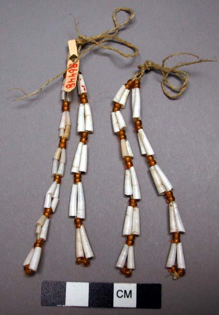 Woman's earrings of dentalium shells strung in two's with beads in-between.