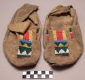 Pair of moccasins, possibly Ute. Rawhide soles w/ leather uppers.